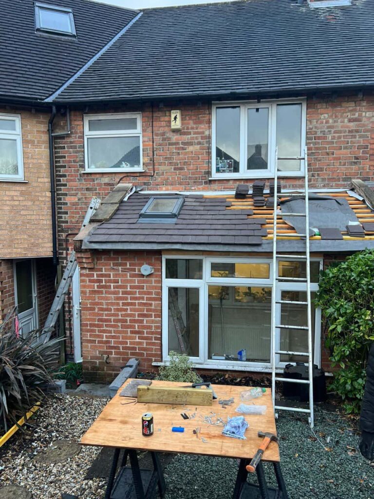 This is a photo taken from the roof ridge looking down a tiled pitched roof on to a flat roof. Works carried out by Coseley Roofing Repairs